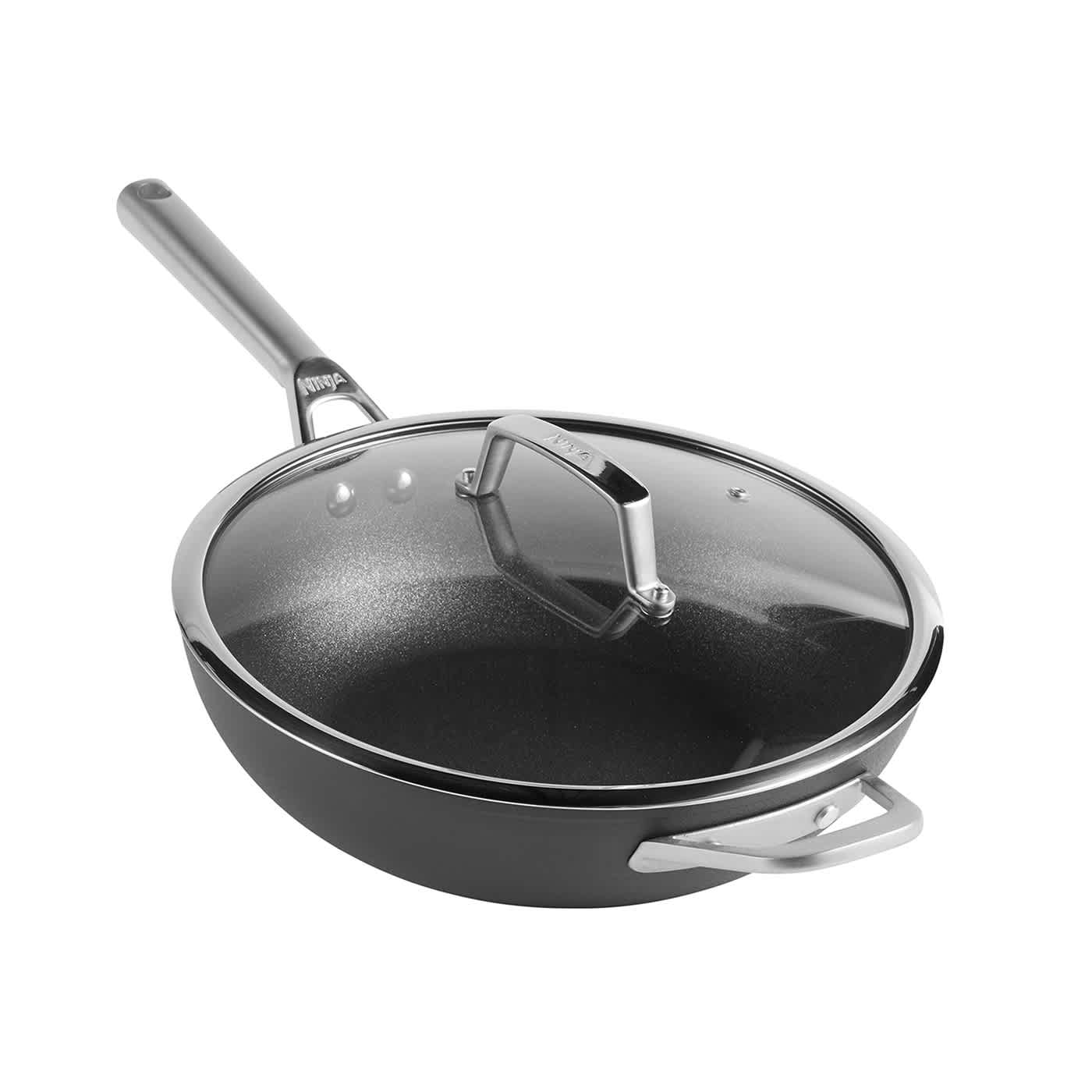 A Ninja black wok with a long handle, helper handle, and a glass lid.
